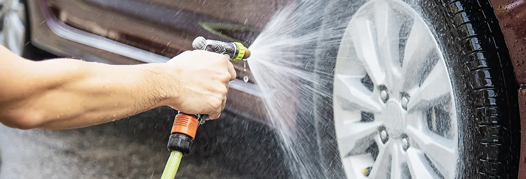 Rinsing car wheels thoroughly on white background