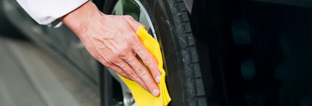 Drying car wheels with a towel on white background